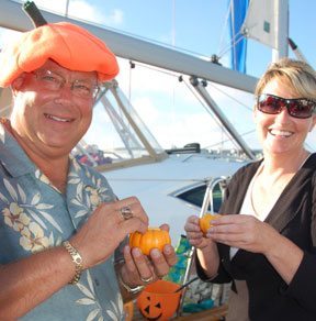 Two people holding pumpkins on a sailboat