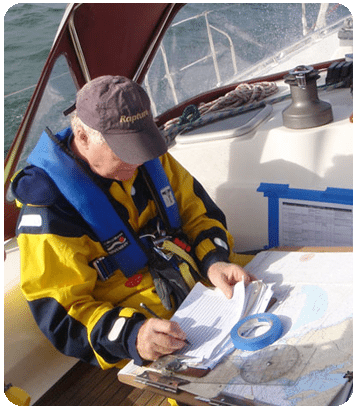 Man filling out paperwork and charts on a sailboat