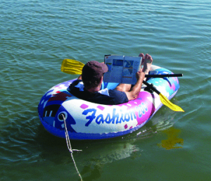 Man reading a magazine while sitting on a water float
