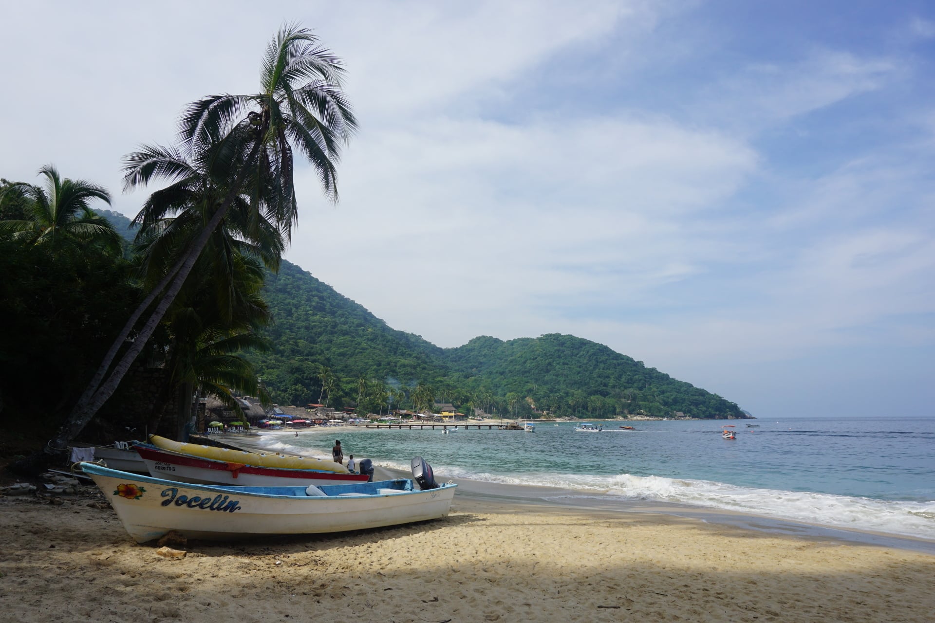 Two small fishing boats on a tropical beach